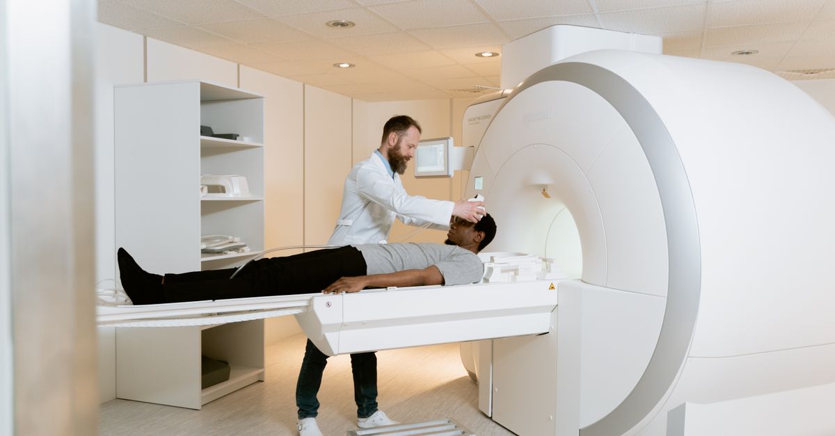 An adult patient experiencing a medical scan guided by a healthcare professional in a modern facility.